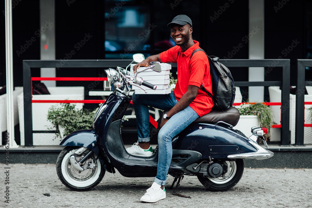 Pizza delivery man carries stack of boxes, works on scooter, conveys fast food from restaurant for customers, wears casual neat clothes, headgear, isolated on purple background. Take your order.