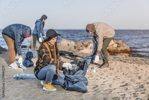 Team of young volunteers are picking up plastic on a beach