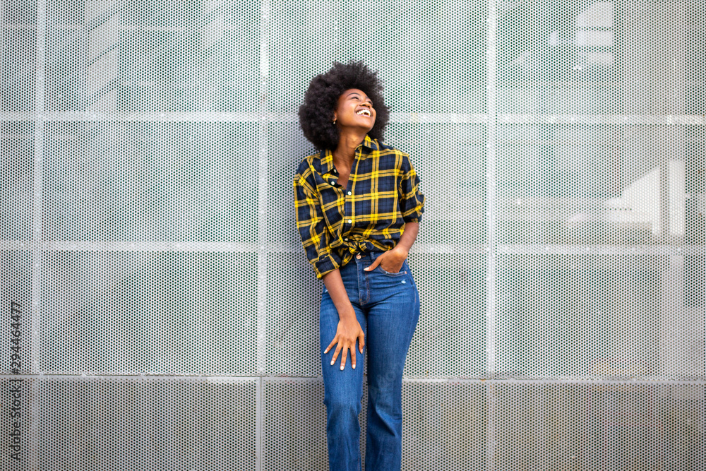 cheerful young black woman laughing and looking up - obrazy, fototapety, plakaty 