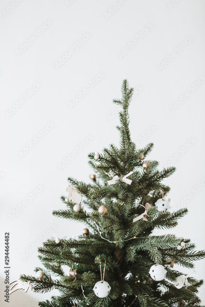 Christmas, New Year fir-tree decorated with toys, Christmas balls, bows on white background. Winter holidays minimal composition.