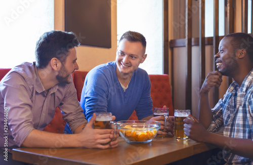 Three young guys having good time at bar