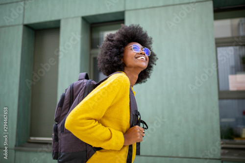 Konstfotografi happy african female college student with glasses and bag