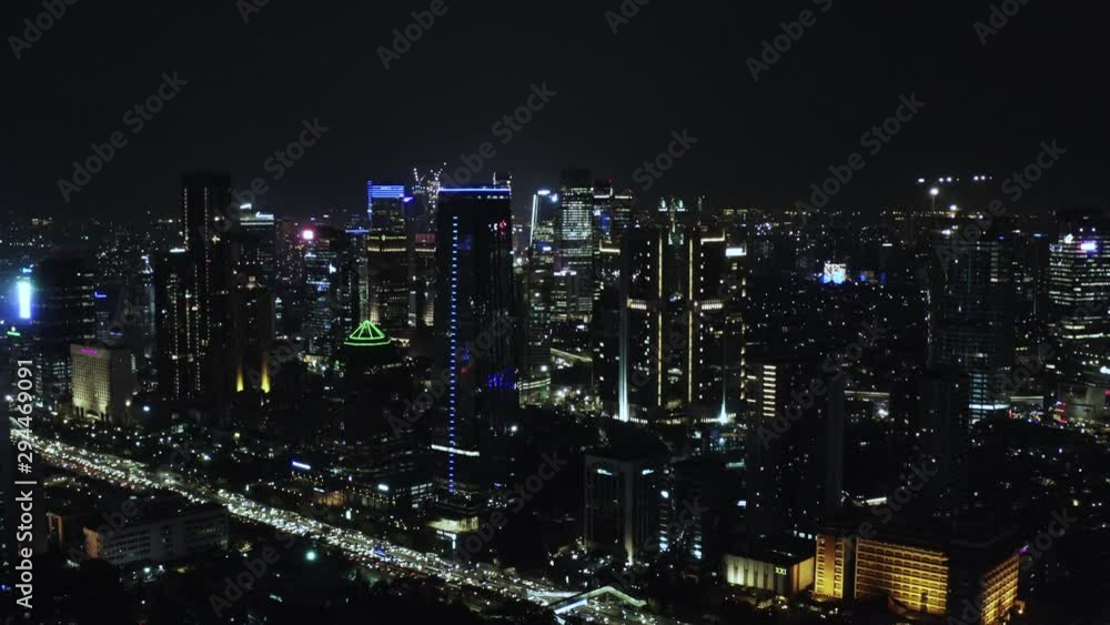 JAKARTA, Indonesia - October 03, 2019: Aerial view of night city with beautiful night lights on modern skyscrapers. Shot in 4k resolution from a drone flying backwards JAKARTA, Indonesia - October 03, 2019: Aerial view of night city with beautiful night lights on modern skyscrapers. Shot in 4k resolution from a drone flying backwards