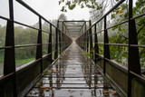 Metal bridge in the rain with diminishing perspective. Steel construction.