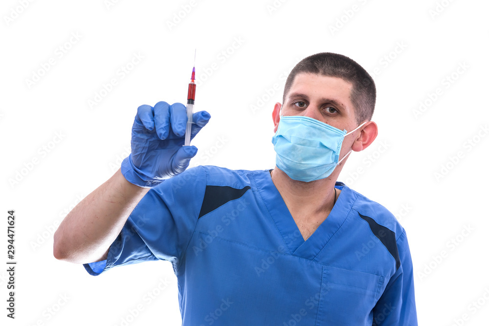 Doctor in mask with syringe with red medicament. He's wearing blue uniform and protective mask Doctor in mask with syringe with red medicament. He's wearing blue uniform and protective mask