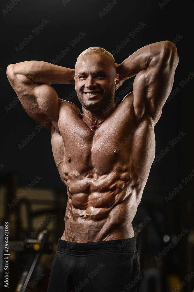 Handsome strong athletic men pumping up muscles workout fitness and bodybuilding concept background - muscular bodybuilder fitness man doing abs exercises in gym naked torso.