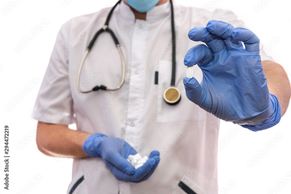 Doctor showing white pills. Male hands in gloves holding tablets isolated on white Doctor showing white pills. Male hands in gloves holding tablets isolated on white