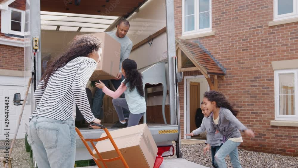 Family Unloading Furniture From Removal Truck Into New Home Family Unloading Furniture From Removal Truck Into New Home