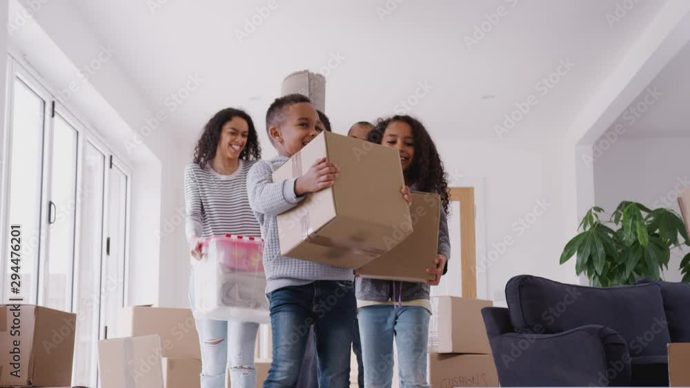 Smiling Family Carrying Boxes Into New Home On Moving Day Smiling Family Carrying Boxes Into New Home On Moving Day