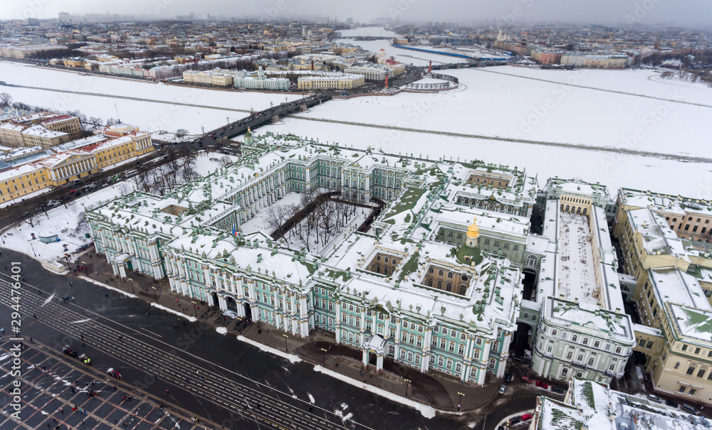 The Winter Palace from Palace Square, aerial view. Panorama of the Neva river with Palace Bridge and the Vasilyevsky Island at winter season. Saint-Petersburg, Russia