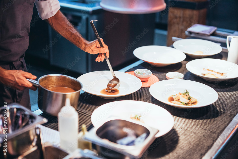Professional chef serving food on plates
