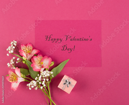 Valentine's day concept. Bouquet of alstroemeria and write Happy Valentine's Day on a red paper background. Top wive