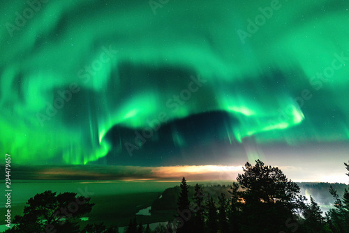 Fotografie View of brilliant green Aurora shining over Swedish foggy forest landscape in mo