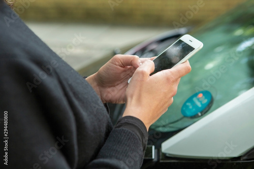 Close up woman using smart phone to access car share