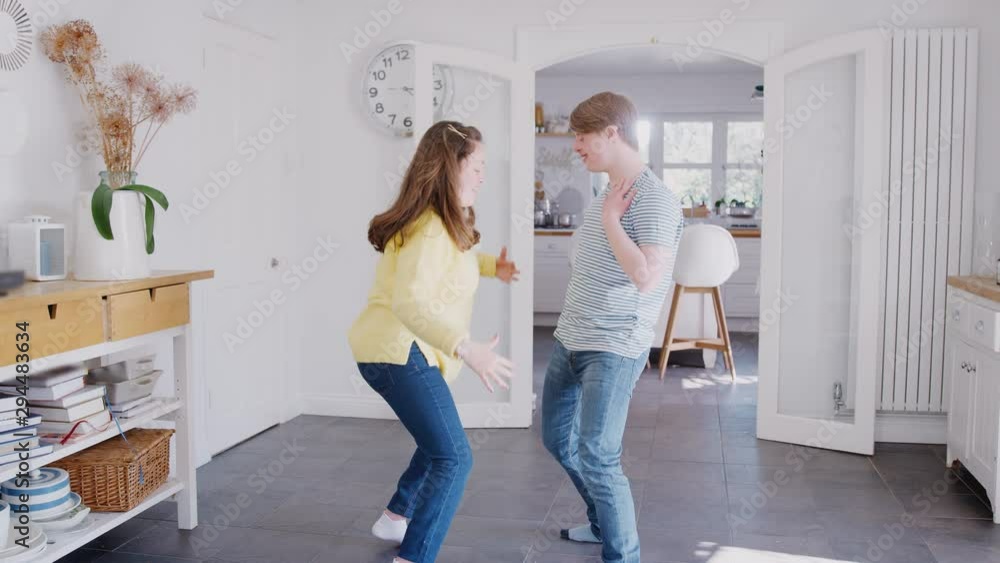 Young Downs Syndrome Couple Having Fun Dancing At Home Together Young Downs Syndrome Couple Having Fun Dancing At Home Together