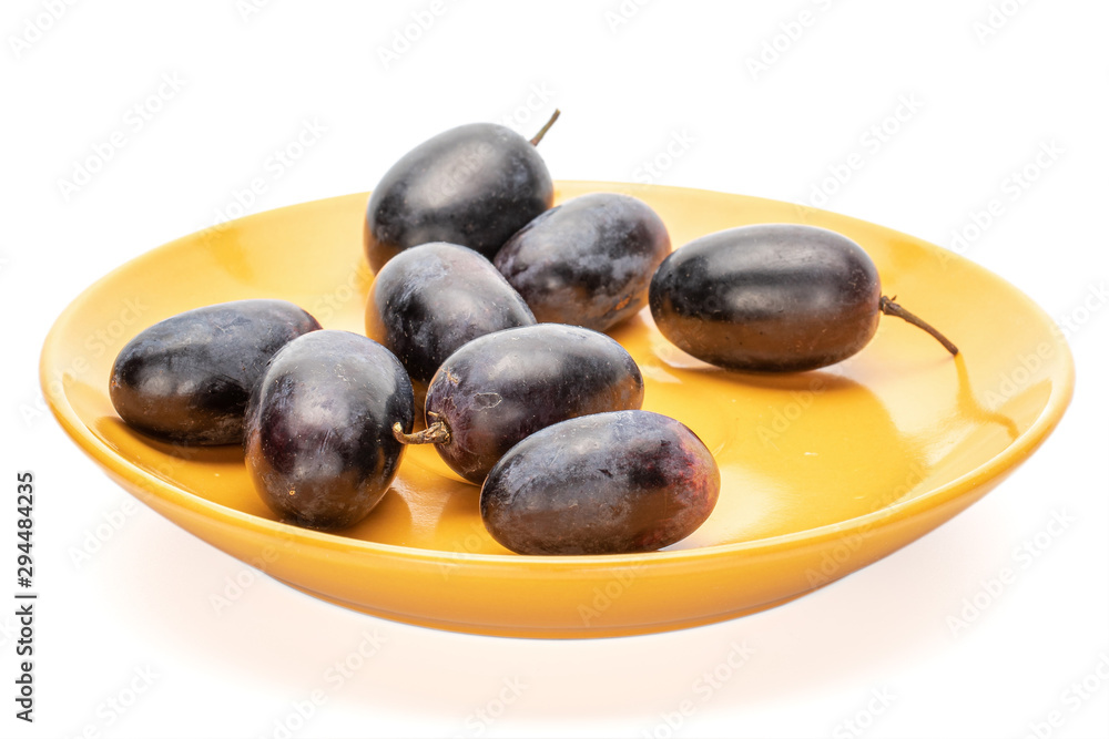 Group of eight whole fresh black grape on orange plate isolated on white background Group of eight whole fresh black grape on orange plate isolated on white background
