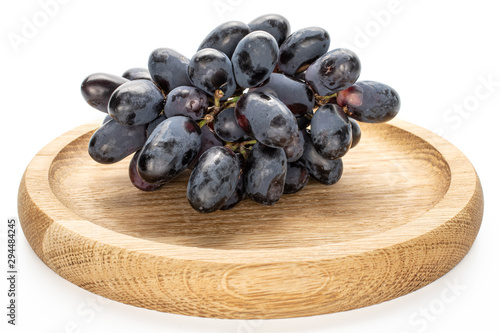 Lot of whole fresh black grape on bamboo plate isolated on white background photo