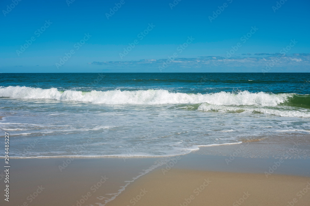 Ocean wave crashing on shoreline on a nearly cloudless day Ocean wave crashing on shoreline on a nearly cloudless day