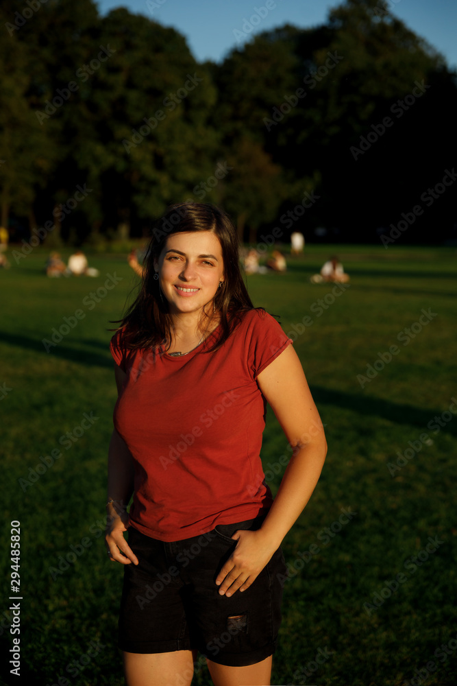 Portrait of a cute girl in the city. girl on the lawn in a city park Portrait of a cute girl in the city. girl on the lawn in a city park