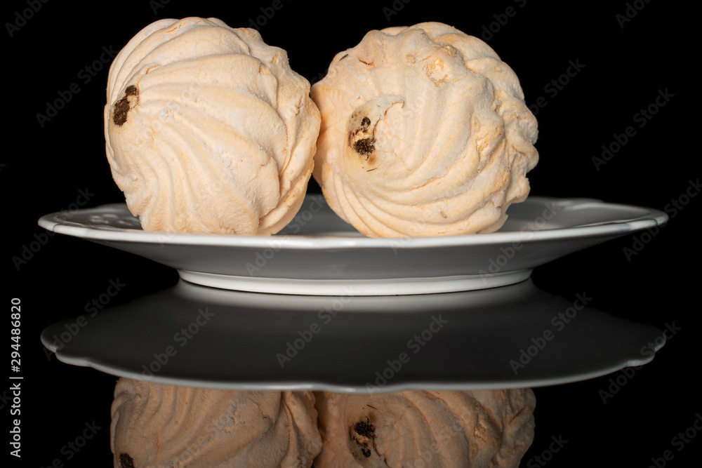 Group of two whole apricot fresh pastel zefir on white plate isolated on black glass Group of two whole apricot fresh pastel zefir on white plate isolated on black glass