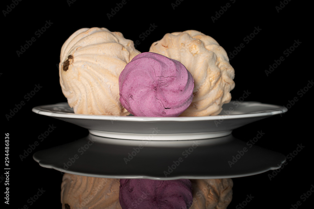 Group of three whole fresh pastel zefir on white plate isolated on black glass Group of three whole fresh pastel zefir on white plate isolated on black glass