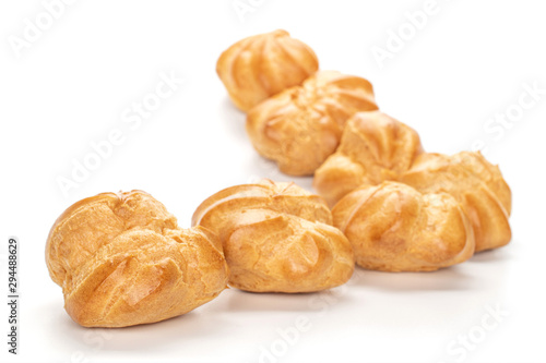 фотографія Group of seven whole baked golden profiterole triangle isolated on white backgro