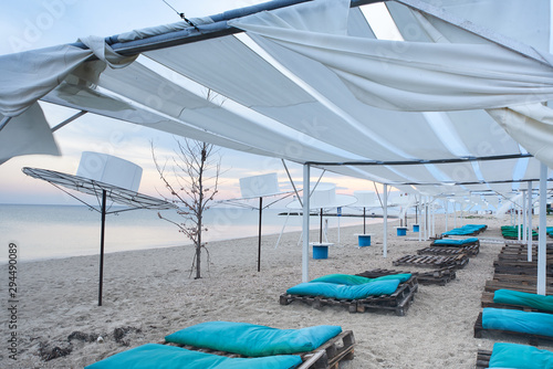 Beach canopies with sun loungers by the sea