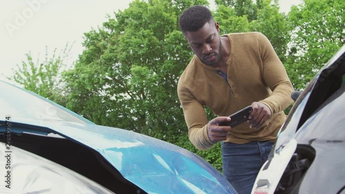 Drivers Involved In Car Accident Taking Pictures Of Damage And Calling Insurance Company