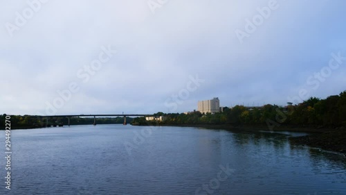 Very wide view of the 395 bridge over the Penobscot River in Bangor, Maine with storage buildings and a high-rise in the distance. photo