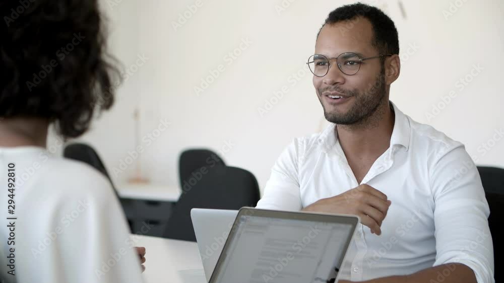 Cheerful manager talking and shaking hands with clients. Smiling African American man working with business partners. Agreement concept Cheerful manager talking and shaking hands with clients. Smiling African American man working with business partners. Agreement concept