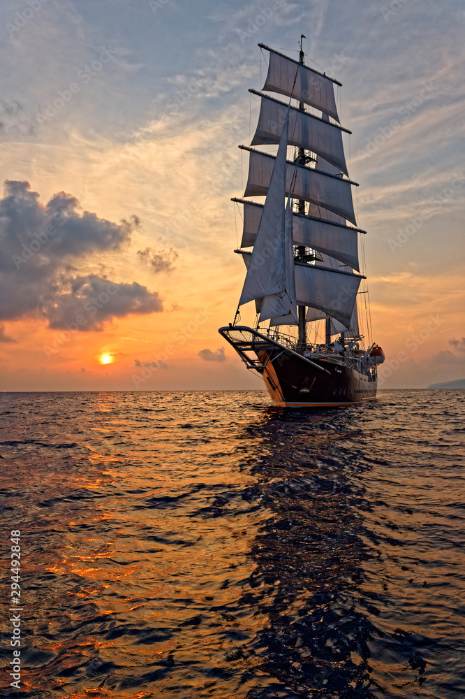 Beautiful sea at sunset and a sailing ship under white sails. Yachting