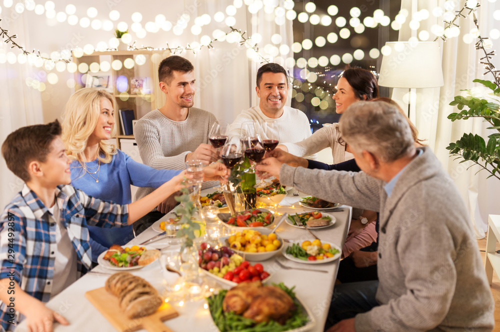 celebration, holidays and people concept - happy family having dinner party, drinking red wine and toasting at home celebration, holidays and people concept - happy family having dinner party, drinking red wine and toasting at home