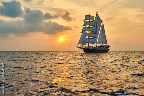Beautiful sea at sunset and a sailing ship under white sails. Yachting
