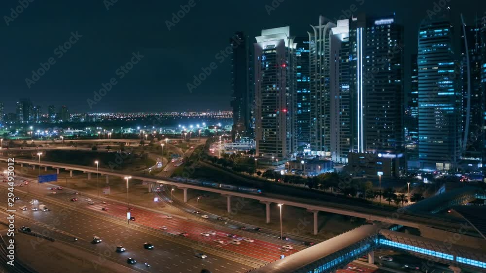 Aerial panoramic view to Sheikh Zayed road from Dubai Marina with JLT illuminated skyscrapers night view, Dubai. Traffic, bridges and metro line. United Arab Emirates Aerial panoramic view to Sheikh Zayed road from Dubai Marina with JLT illuminated skyscrapers night view, Dubai. Traffic, bridges and metro line. United Arab Emirates