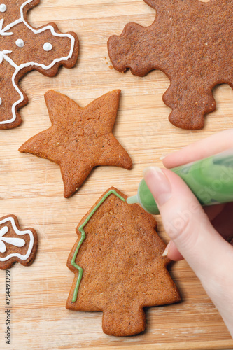 Christmas gingerbread homemade cookies decorating process with sweet icing, View from above