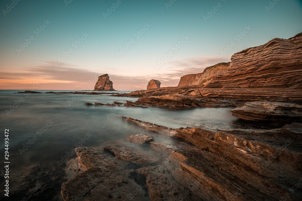 Rocks of Two Sisters of Hendaye with bluish green sunset sky. France