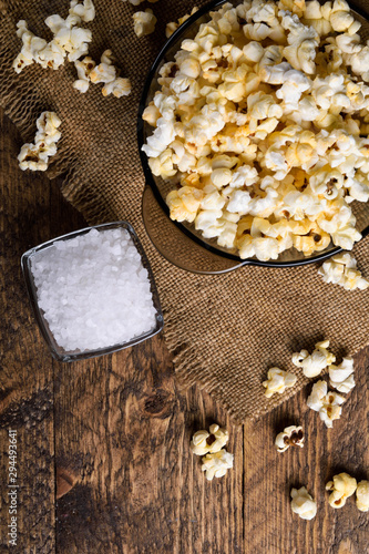 Air salty popcorn.A bowl of popcorn on a wooden table.Salt popcorn on the wooden background .  With space for text.Top view.popcorn texture.Chees .