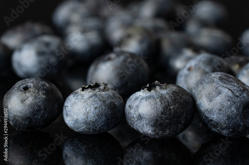 Lot of whole fresh blue blueberry isolated on black glass photo