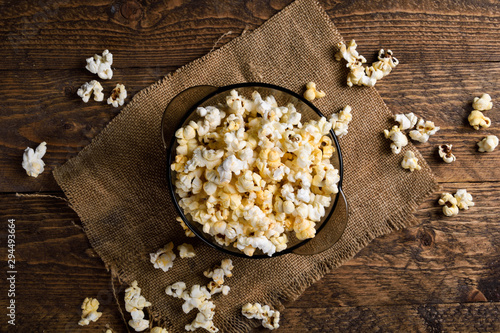 Air salty popcorn.A bowl of popcorn on a wooden table.Salt popcorn on the wooden background . With space for text.Top view.popcorn texture.Chees .