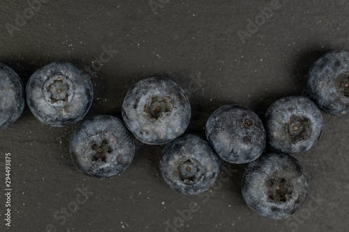 Lot of whole fresh blue blueberry flatlay on grey stone photo