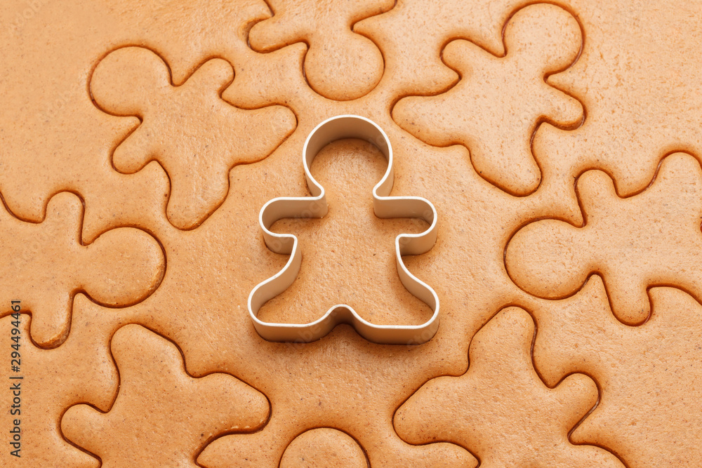 Gingerbread men background. Christmas baking texture with cutter Gingerbread men background. Christmas baking texture with cutter