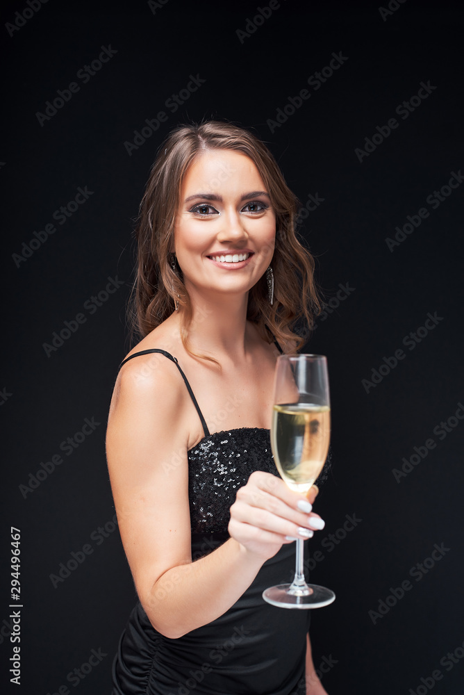 Young happy woman in elegant dress with glass of champagne at party. Young happy woman in elegant dress with glass of champagne at party.