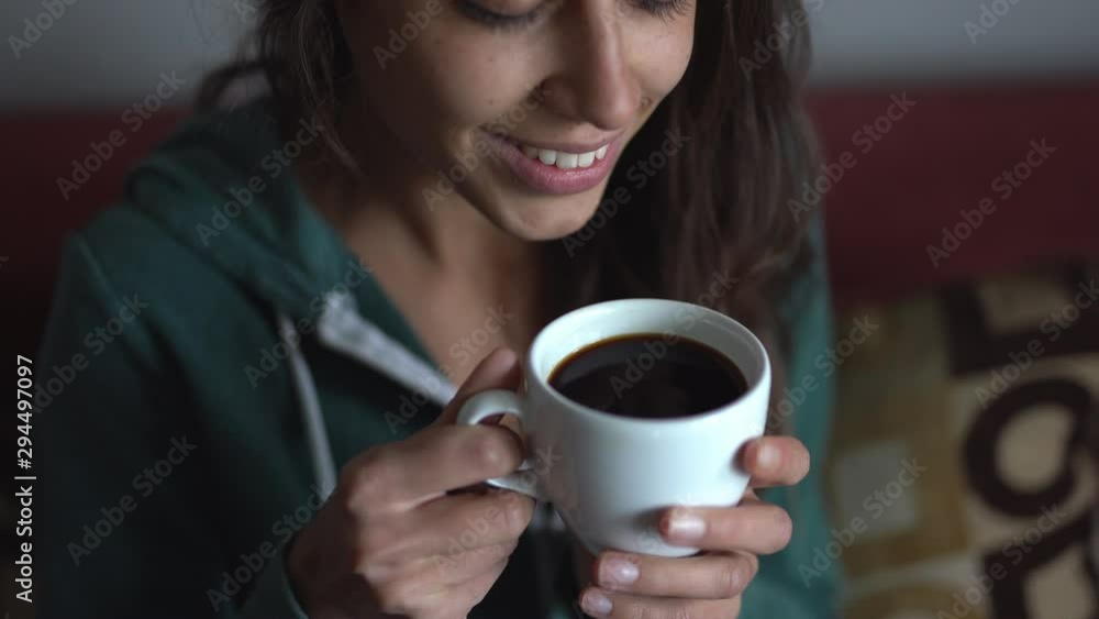 closeup of attractive young woman drinking coffee at home. woman enjoys the aroma and taste of freshly made coffee closeup of attractive young woman drinking coffee at home. woman enjoys the aroma and taste of freshly made coffee