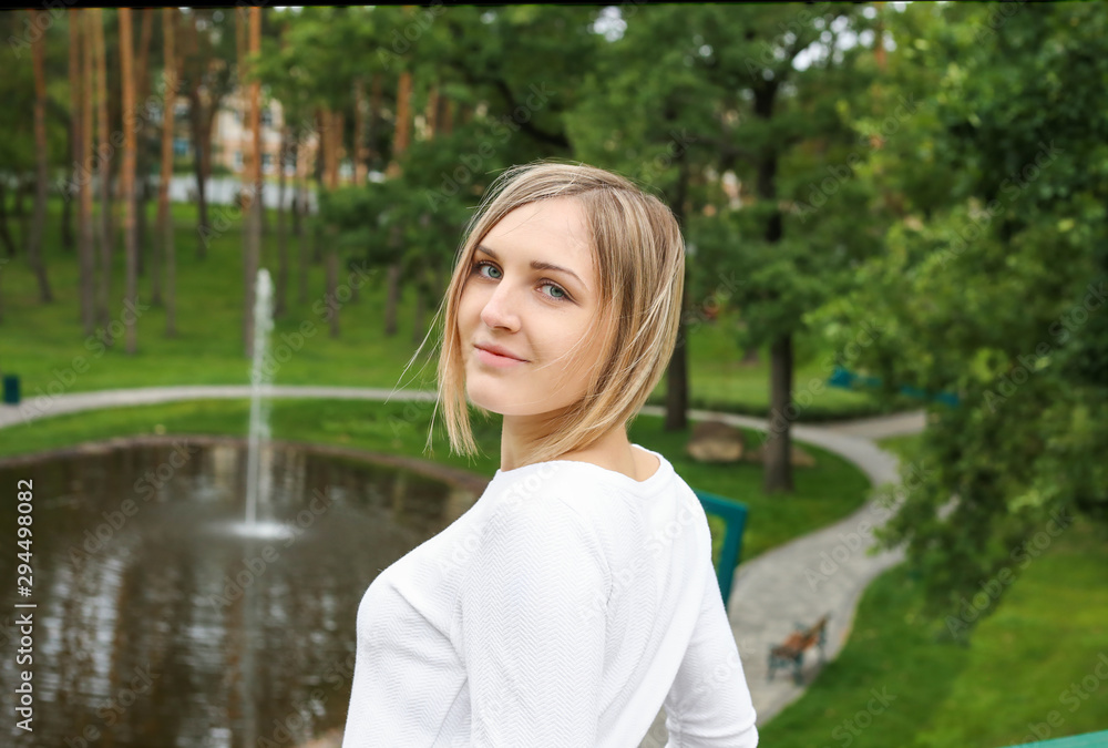 portrait of a beautiful girl on a background of a park with a lake and fountains. European appearance portrait of a beautiful girl on a background of a park with a lake and fountains. European appearance