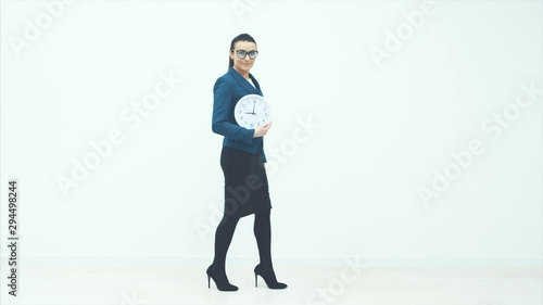 Portrait of beautiful young business woman holding in hands clock, isolated on white background, discipline and punctual concept.