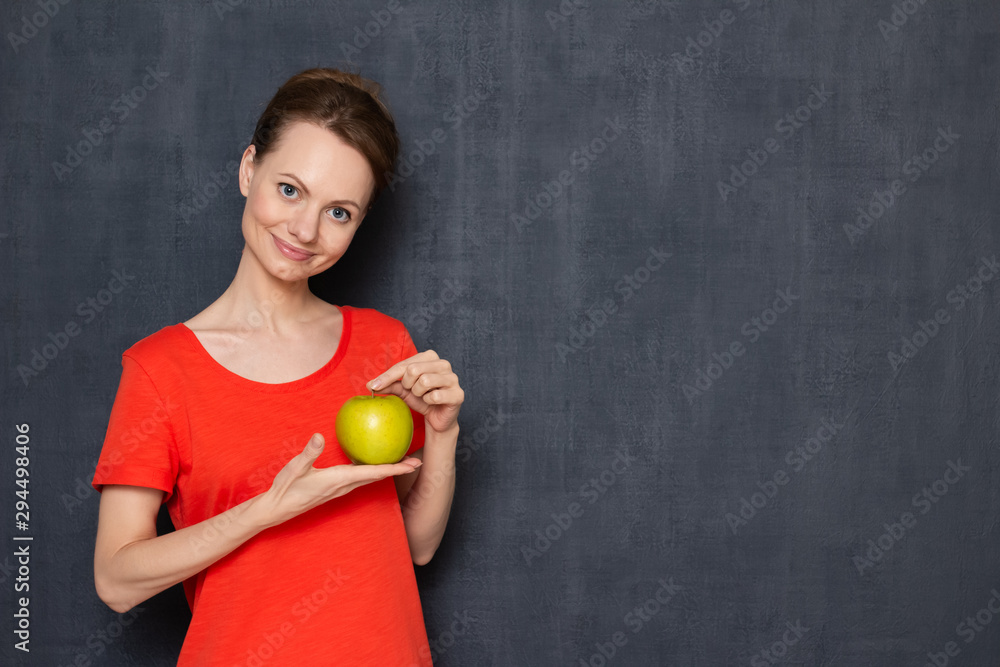 Portrait of happy young woman gently holding yellow-green apple Portrait of happy young woman gently holding yellow-green apple