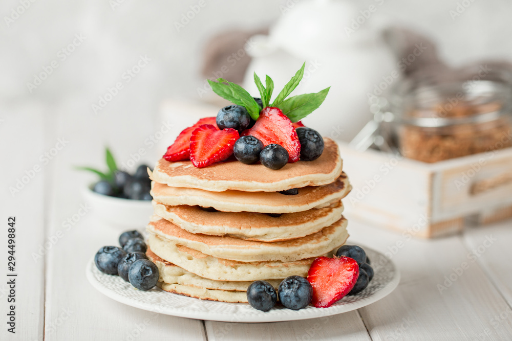 Classic american pancakes with fresh berry on white wood background. Summer homemade breakfast. - obrazy, fototapety, plakaty 