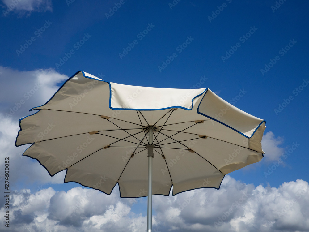 white beach umbrella  . Blue sky with  white clouds background