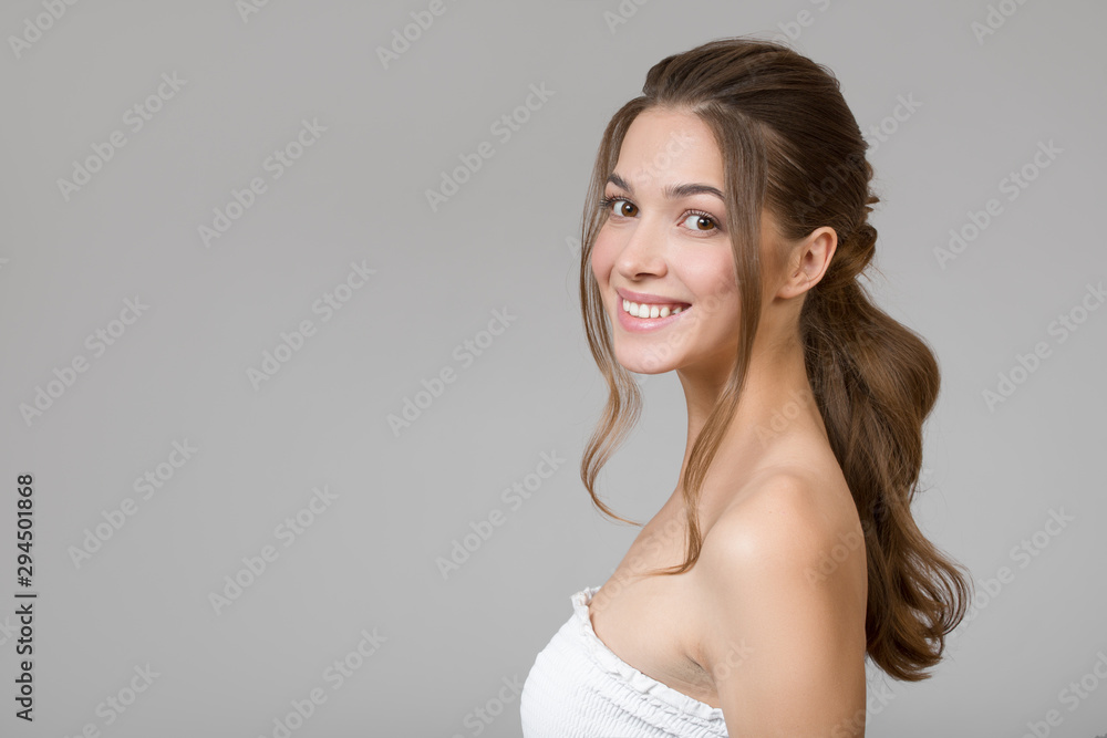 Portrait of a beautiful woman. Lovely smile on a gray background Portrait of a beautiful woman. Lovely smile on a gray background