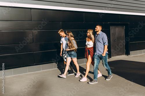 Group of stylish friends, girls and guys walk together on in the city